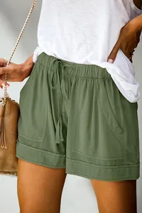 Primo piano di pantaloncini casual verde oliva con coulisse in vita e tasche comode.