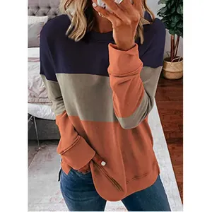 Detail view of a loose-fit color-block sweatshirt with navy, grey, and orange segments.