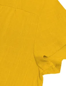 Macro detail showing the high-quality fabric texture and seam of a yellow woven dress