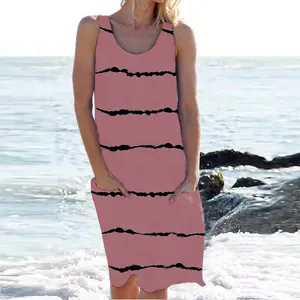 Detalle de un vestido de verano rosa sin mangas a rayas con bolsillos en la playa.
