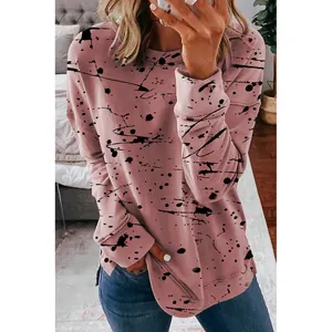 Detailed view of women's pink long-sleeved sweatshirt with stylish black ink splatter pattern
