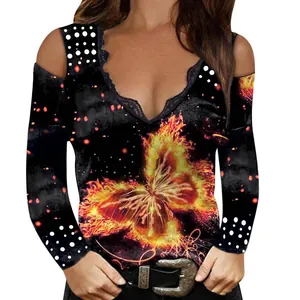 Detail view of the lace V-neck and fiery butterfly print on a black cold-shoulder top