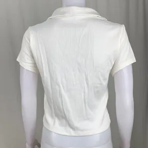 Vista posteriore di una polo bianca a maniche corte in maglia a coste con vestibilità slim.