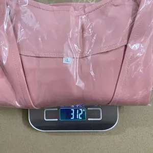Detailed view of a folded pink plus size blazer on a digital scale weighing 312 grams