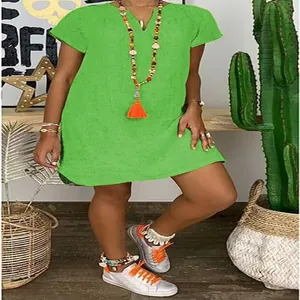 Close-up detail of loose-fit V-neck woven dress in green with colorful boho accessories
