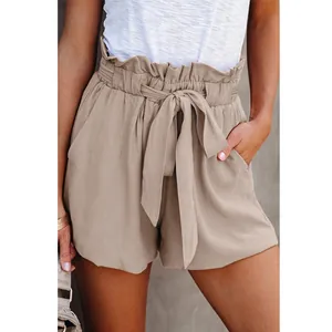 Close-up of stylish paper-bag waist shorts with tie-belt and side pockets in beige