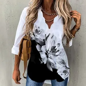 Detailed view of elegant white long-sleeved shirt with wave neck and black floral print