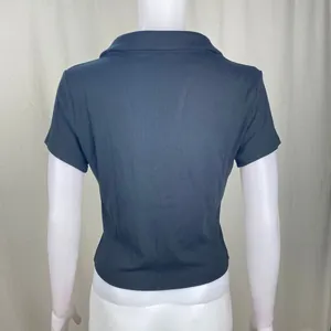 Vista posteriore dettagliata di un crop top polo nero a maniche corte a costine.