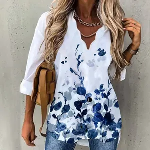 Close-up of an elegant long-sleeve blouse featuring a wave V-neck and blue floral ink print