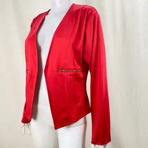 Side view detail of red women's blazer with silver-toned zipper pocket accents.