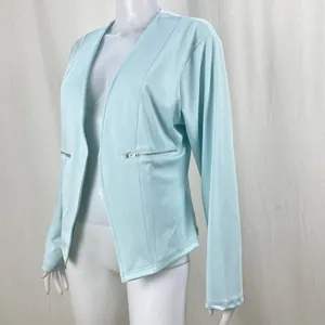 Detail of mint green women's suit jacket featuring silver zipper pockets and slim fit.