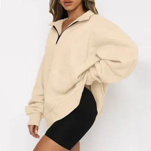 Dettaglio di una felpa beige da donna oversize con mezza zip e maniche a spalla scesa