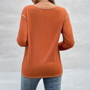 Rear view of a casual orange long-sleeved women's T-shirt with visible stitching detail