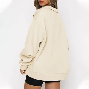 Back view of women's beige half-zip sweatshirt showing oversized fit and fleece fabric.