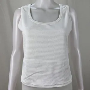 Macro detail view showing the textured waffle knit fabric of a white U-neck tank top