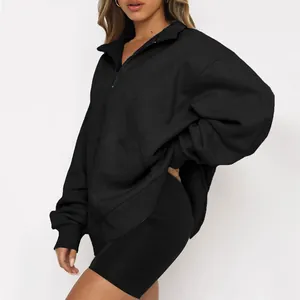 Vista dettagliata di una felpa oversize nera con mezza zip da donna e pantaloncini da ciclista.