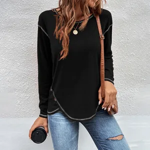 Detail view of black long-sleeve T-shirt with asymmetrical curved hem and buttons.