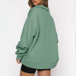 Vista posteriore di una felpa verde a mezza zip dalla vestibilità comoda su una modella