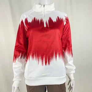 Close-up detail of the red and white gradient print on a quarter-zip mock neck sweatshirt.
