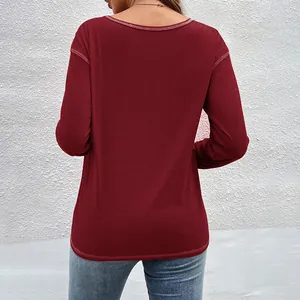 Detailed back view of a burgundy long-sleeved T-shirt with white contrast stitching