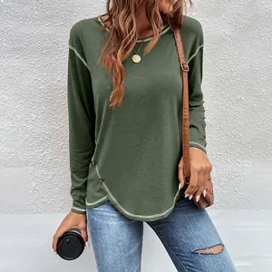 Detailed view of dark green long sleeve t-shirt featuring button accents and curved hem.