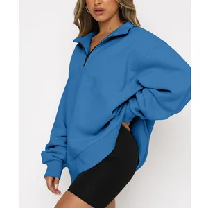 Close-up detail of a blue oversized women's half-zip sweatshirt with a soft fleece texture