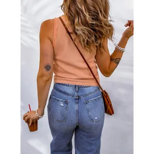 Detailed back view of a trendy peach waffle knit tank top paired with casual blue denim jeans