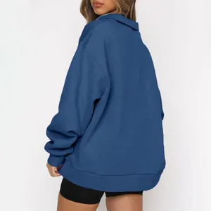 Vista posteriore di una comoda felpa blu oversize da donna con mezza zip e maniche lunghe