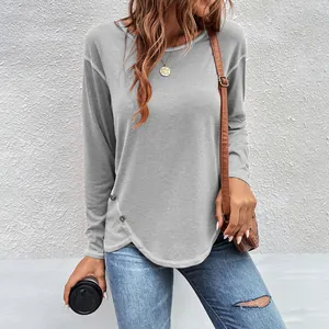 Detail view of grey long-sleeved T-shirt featuring decorative buttons and curved hem