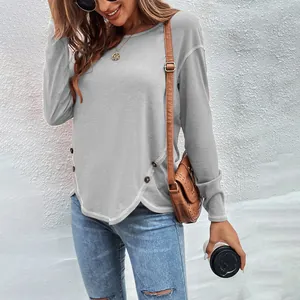 Detail view of women's grey long-sleeve shirt with irregular buttoned hem design