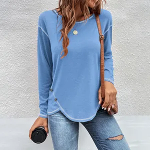 Detail view of blue long sleeve t-shirt with irregular hem and button accents
