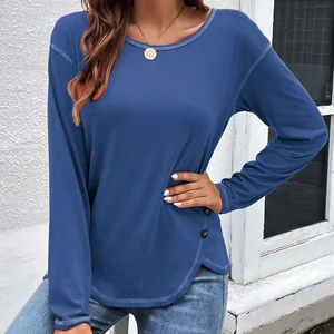 Close-up of blue long-sleeved T-shirt featuring decorative buttons and irregular hem