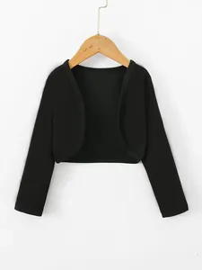 Close-up of black long-sleeved cropped bolero shrug jacket hanging on wooden hanger