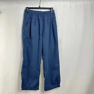 Women's loose casual solid blue trousers with elastic waist shown in hanging view