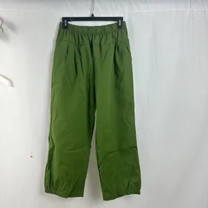Detail view of women's loose casual pants in vibrant green with elastic waist