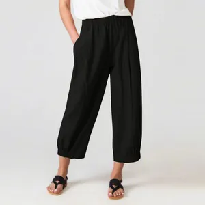 Detail view of women's black loose casual trousers with elastic waist and cuffed hem.