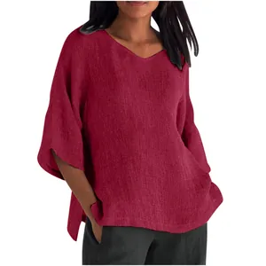 Detail view of a loose red V-neck top with wide mid-sleeves and linen-like texture