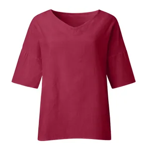 Close-up detail of burgundy V-neck blouse highlighting the breathable linen fabric texture