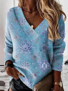 Detailed view of women's V-neck long-sleeve top with blue ethnic floral print pattern.