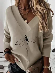 Close-up view of a beige V-neck sweatshirt featuring an artistic dragonfly and Warrior print