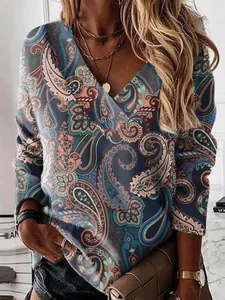 Detailed view of women's long sleeve V-neck top with vibrant paisley print design