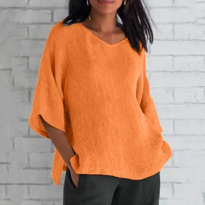 Close-up of elegant V-neck loose orange T-shirt with breathable textured fabric