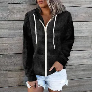 Detailed view of women's black textured zip-up hoodie with hood and white drawstrings