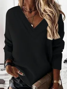 Vista detallada de la elegante camiseta negra de manga larga con cuello en V de capas.
