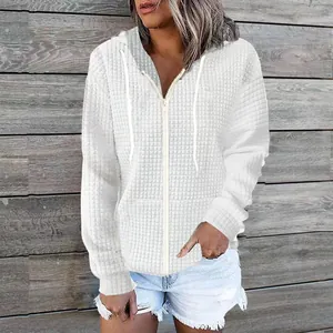 Detailed macro shot of white quilted fabric texture on hooded zip-up sweatshirt for women