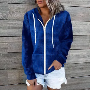 Detailed view of women's blue waffle-knit zip-up hoodie with hood and white drawstrings