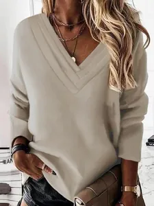 Detalle del exclusivo cuello en V de varias capas en este elegante top beige de manga larga.