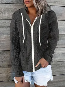 Detail of women's cable-knit zip-up hoodie featuring white drawstrings and zipper