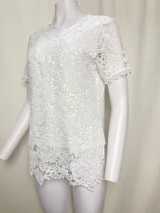Close-up of white rose floral lace pattern on short-sleeve V-neck top.