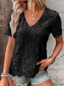 Close-up of an elegant black lace shirt with a V-neckline and intricate embroidery.